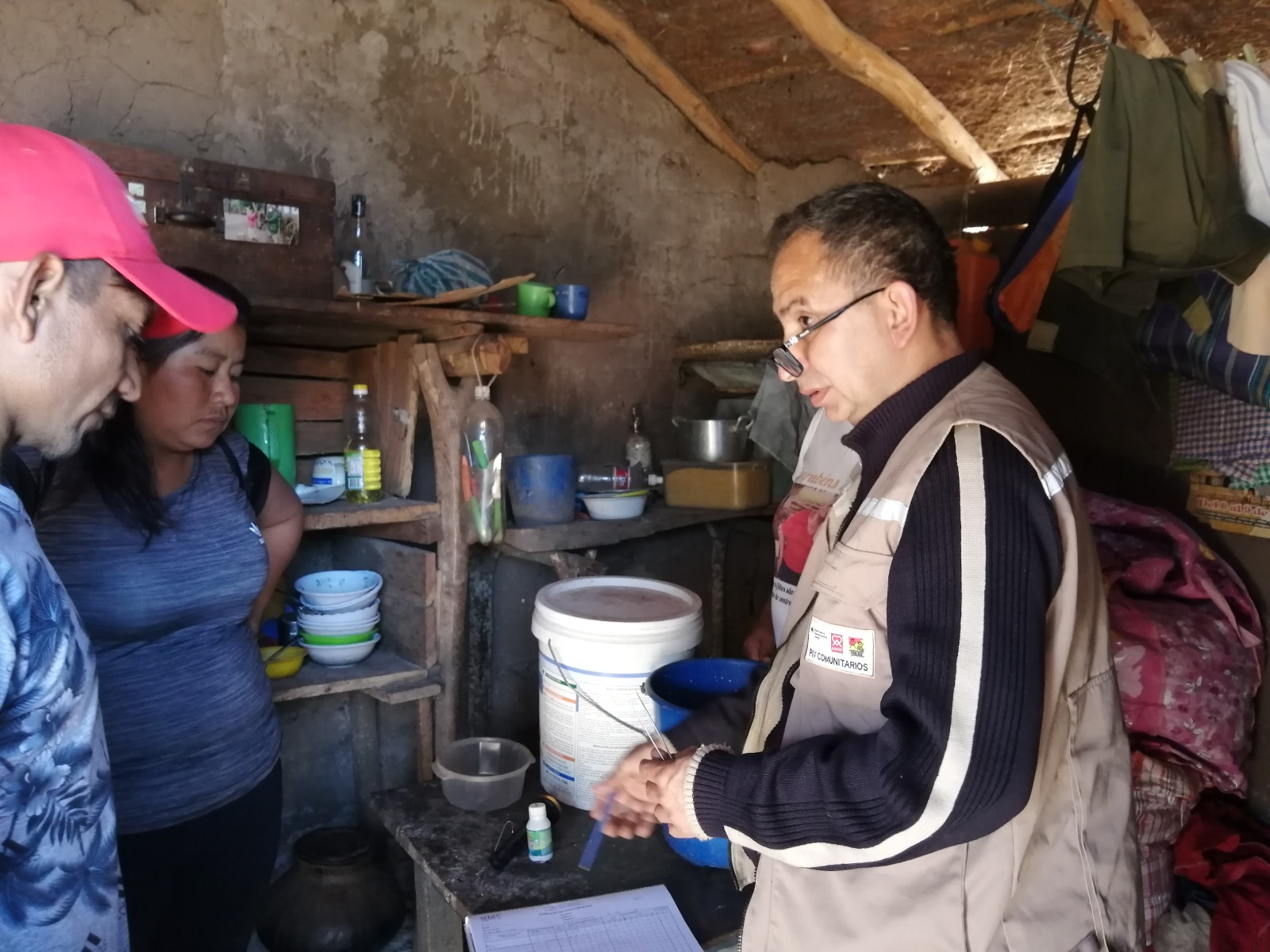 Un agente de salud visita a una paciente de Chagas en su vivienda.